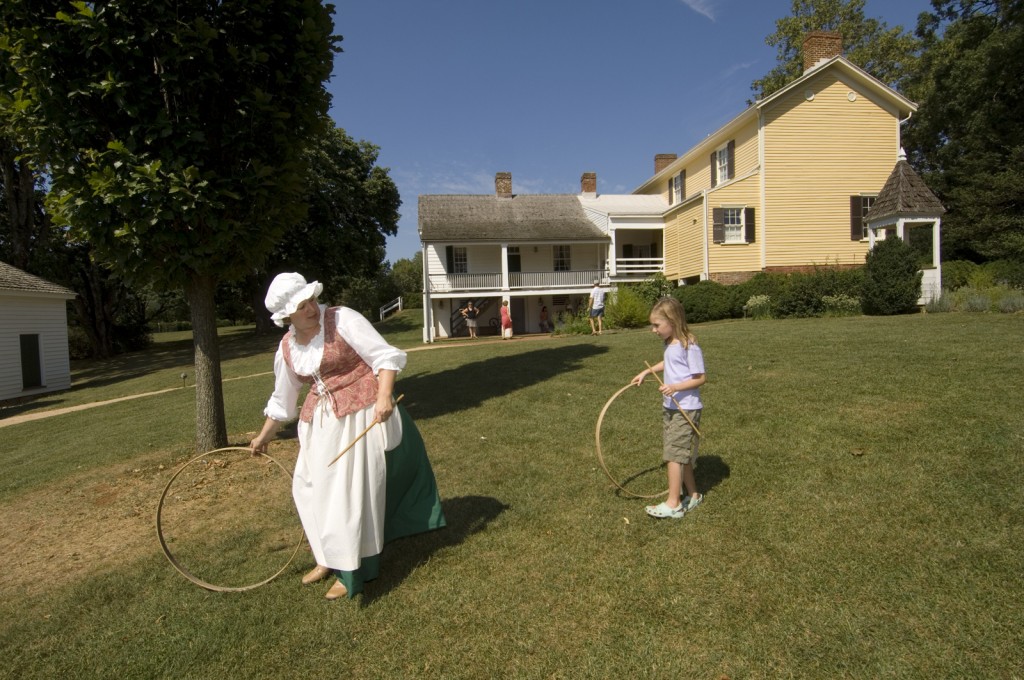 Woman and girl play with wooden hoops at Ash Lawn-Highland 