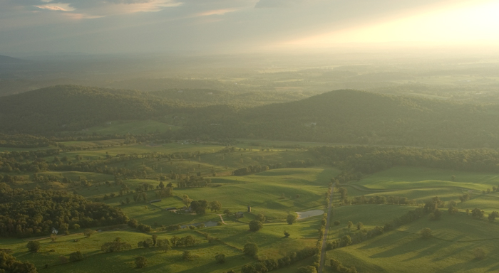 arial view of rolling hills and farm land at sunset