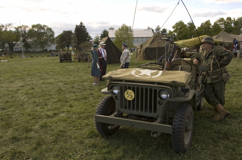 People pose with a restored Jeep