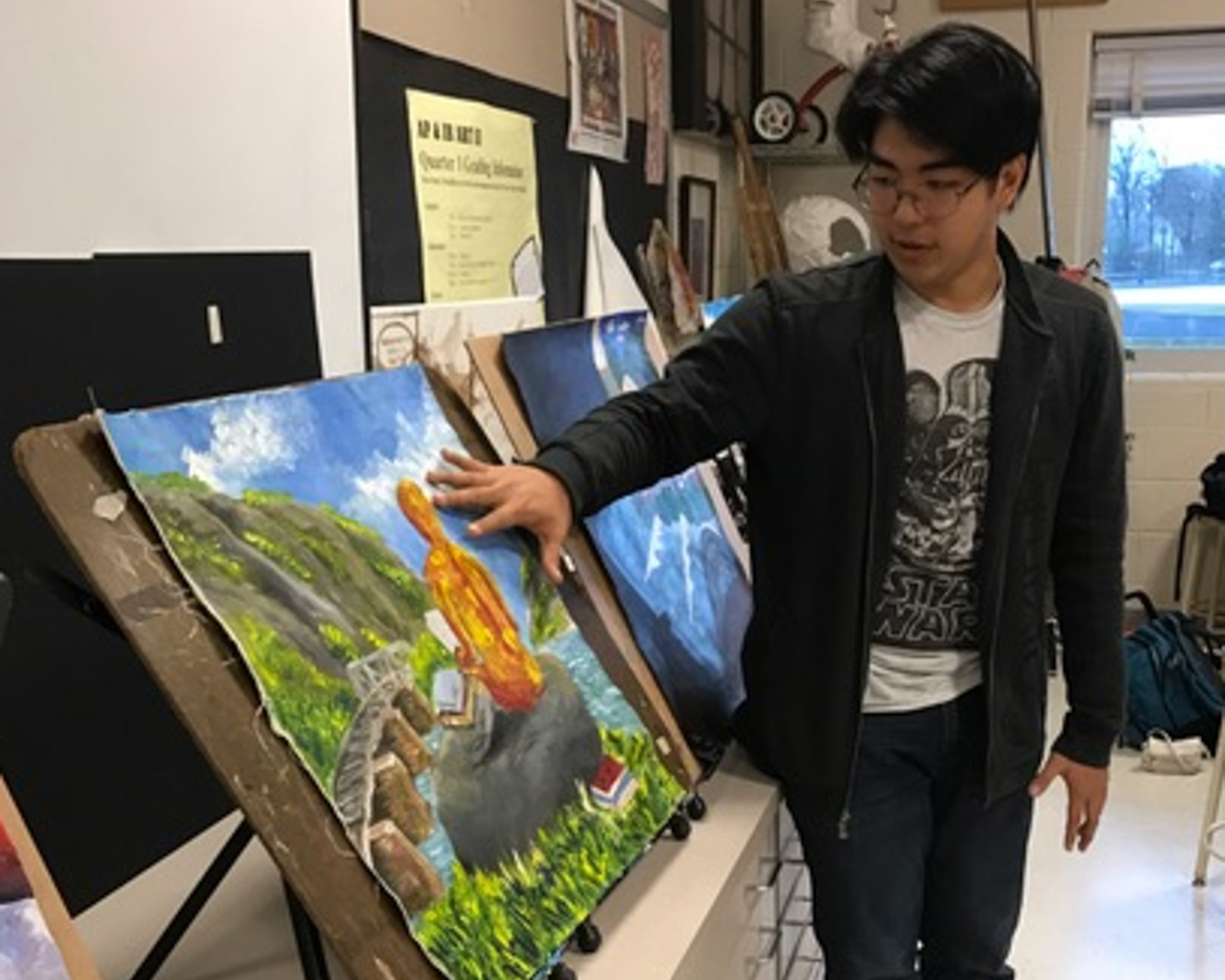student presenting his painting